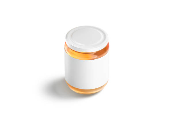 Blank glass jar with white label and honey mockup, isolated, 3d rendering. Empty conservation glassware with honeymead mock up stand, side view. Clear transparent can with sweet mead template.