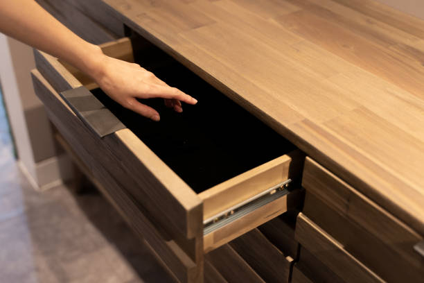 istock Woman open shelf, pull open drawer wooden in cabinet. 1283501240