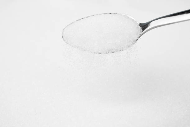 istock Pouring sugar from spoon isolated on white background 1283501279