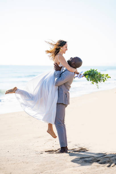 istock Just married honeymoon wedding couple jumping on beach 1283504618