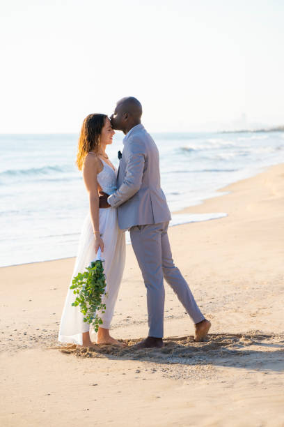 casal de casamentos se beijando em lua de mel na praia - honeymoon wedding beach couple - fotografias e filmes do acervo