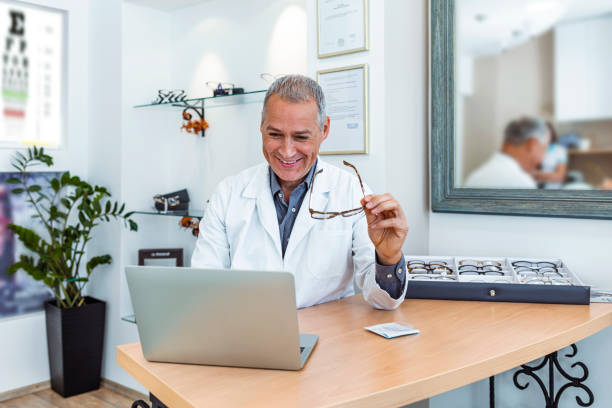 Cheerful male ophthalmologist working at the optical store