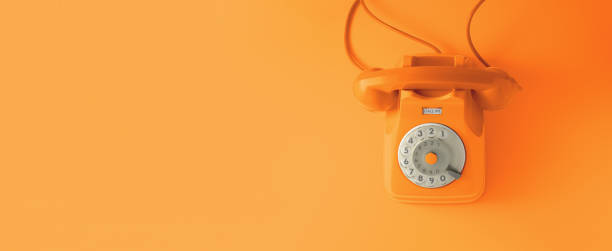 An orange vintage dial telephone. An orange vintage dial telephone with orange background. bakelite stock pictures, royalty-free photos & images