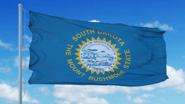 bandera de dakota del sur en un asta de bandera ondeando en el viento, fondo del cielo azul. renderizado en 3d - south dakota fotografías e imágenes de stock