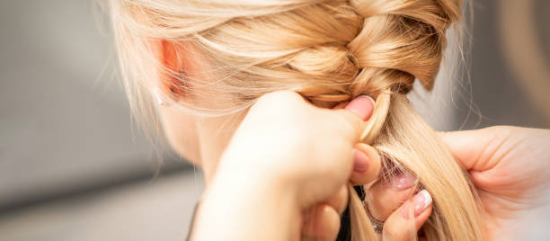 istock Female hands braiding pigtail to woman 1283511108