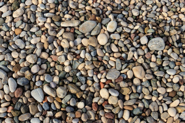 istock Smooth round pebbles texture background. Pebble sea beach close-up 1283511366