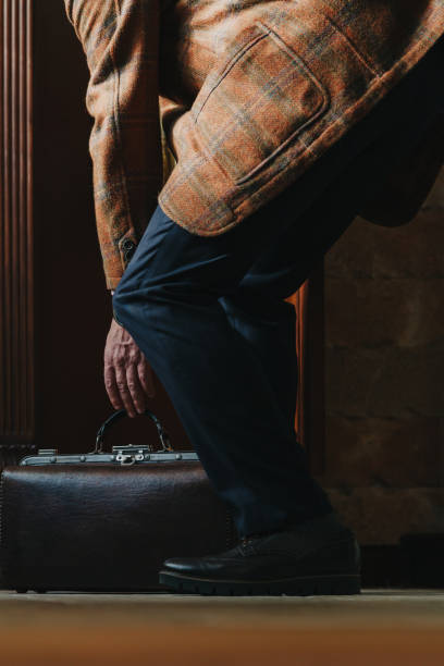 istock Man in jacket puts travel bag on floor 1283512420