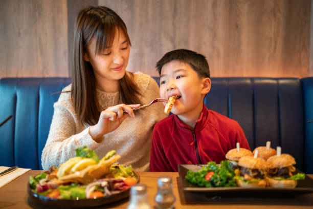 istock Asian woman feeding his son in a cafe 1283515732