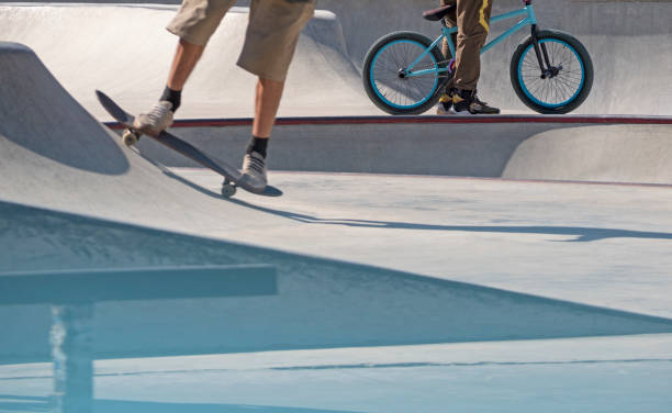 uomini in sella a skateboard e bmx - skateboard park extreme sports recreational pursuit skateboarding foto e immagini stock
