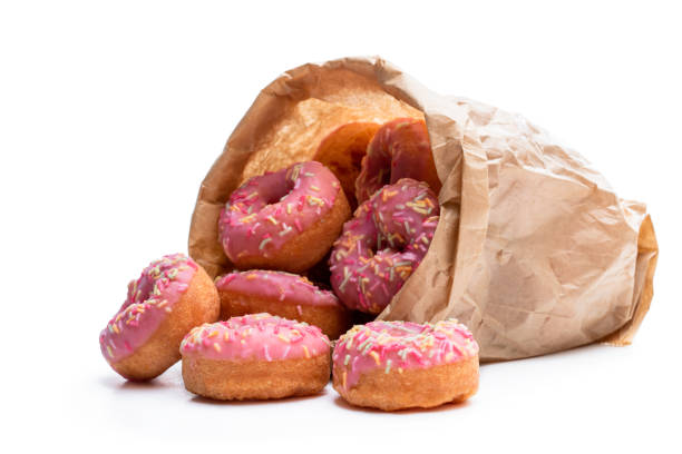 istock Mini pink glazed doughnuts in paper bag isolated on white 1283517906