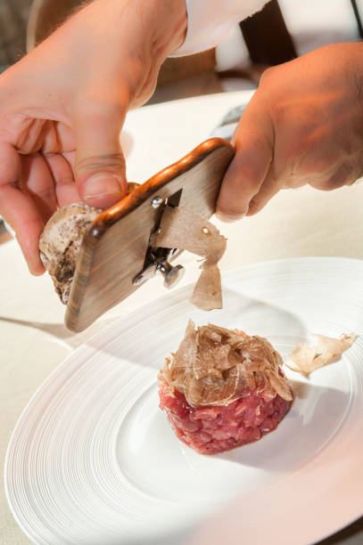 istock Alba white truffle sliced by the waiter's hands on raw minced meat 1283518139