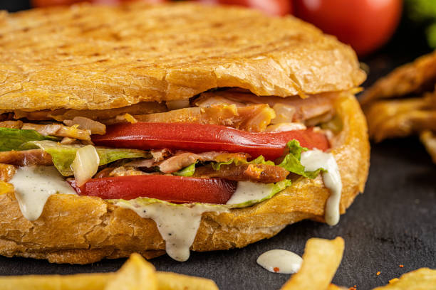 istock Turkish kebab in a fried bun with chicken, tomatoes, salad and cheese on a black background. 1283519032