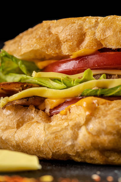 istock Turkish kebab in a fried bun with chicken, tomatoes, salad and cheese on a black background. 1283519034