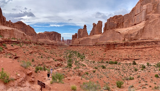 Moab, Utah, USA - July 17, 2020: Group of tourist are walking the Park Avenue Trail in Arches National Park in Utah.