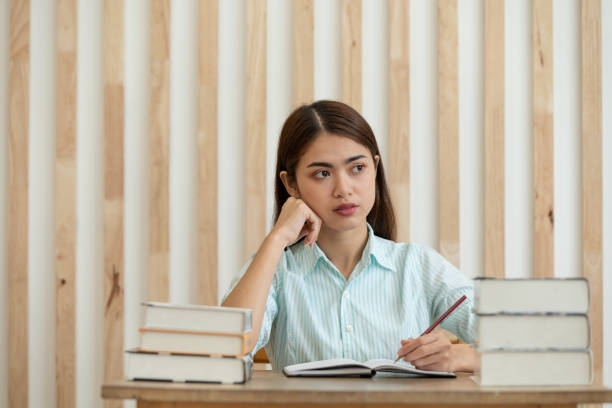 istock Happy young Asian business woman thinking dreaming has many ideas while working in office 1283520443