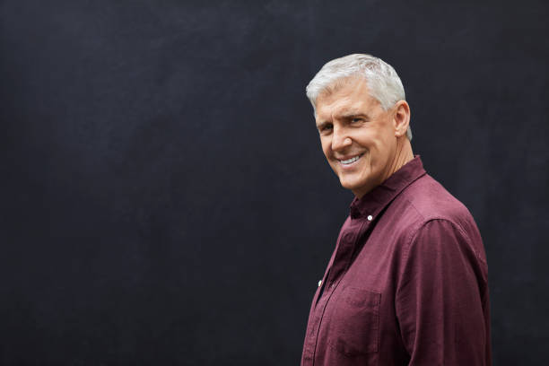 istock Confident mature man standing against gray wall 1283520657