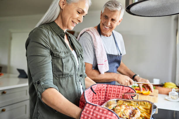 istock Man talking to woman while preparing food at home 1283520700