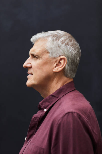 istock Side view of mature man standing against gray wall 1283520847