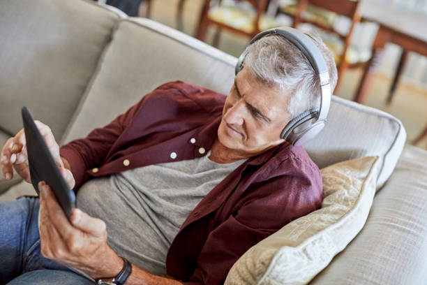 istock Mature male using digital tablet in living room 1283520928
