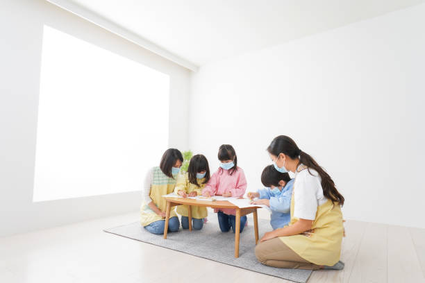istock A kindergartner and his teacher drawing with a mask on 1283521981