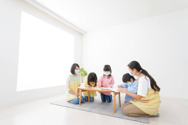 istock A kindergartner and his teacher drawing with a mask on 1283521988