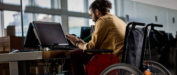 Man in wheelchair Student in the library accessibility for persons with disabilities photos stock pictures, royalty-free photos & images