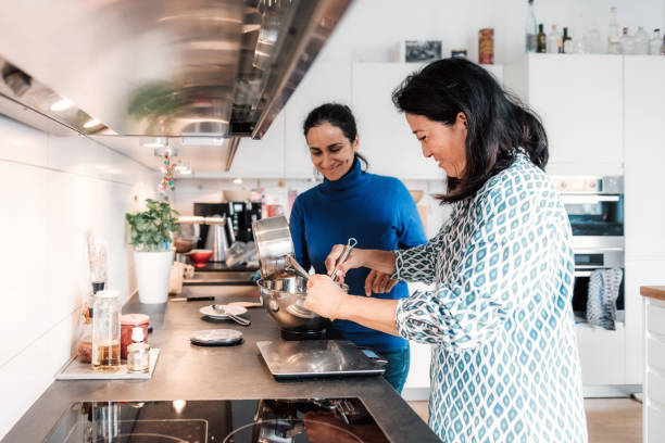 duas mulheres preparando massa na cozinha - family germany baking berlin germany - fotografias e filmes do acervo