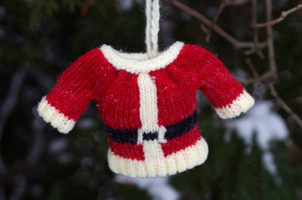 istock mini red knit Santa coat on white background with copy space 1283526844