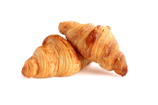 Two classical french croissants on a white background.