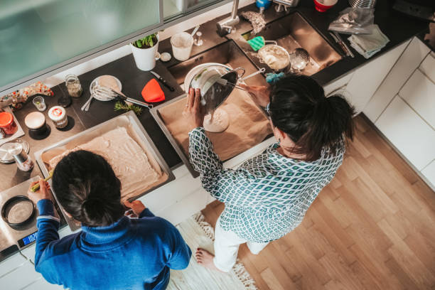 two woman preparing dough on baking sheet in kitchen - family germany baking berlin germany imagens e fotografias de stock