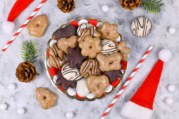 Plate with traditional German gingerbread cookies with sugar and brown and white chocolate glazing in heart and star shape