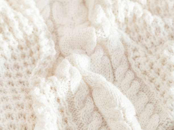 istock Hand made cable-knit sweater sweater. Texture of warm knitted fabric with pattern. White cardigan. Cozy autumn outfit for snuggle weather. 1283530259