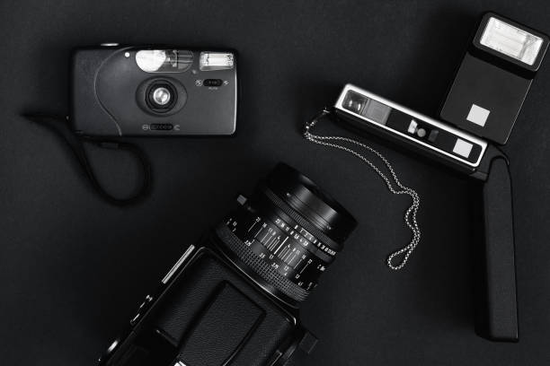 Workspace concept for photographers, top view of a camera equipment on black table background