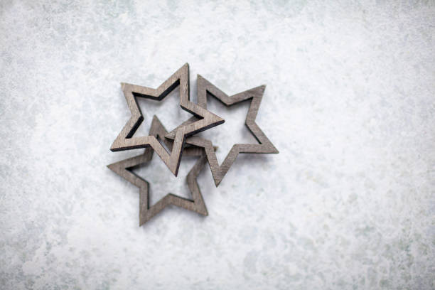 istock Stack of three wooden stars on a light textured background viewed from above 1283533203