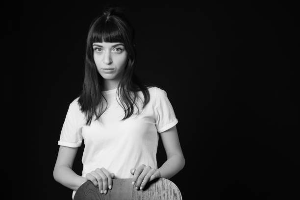 Studio portrait of a young woman against plain black background