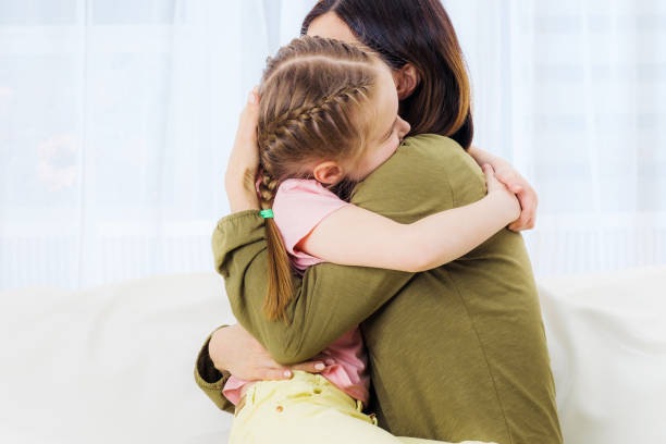 istock Woman and her daughter hugging on couch 1283536620