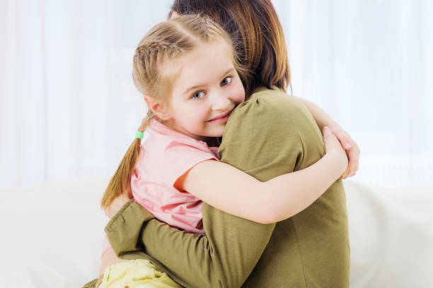 istock Woman and her daughter hugging on couch 1283536622