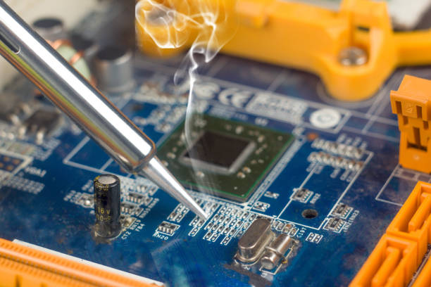 istock use a soldering iron to solder the electronic part to the Board. Computer repair. . 1283538534