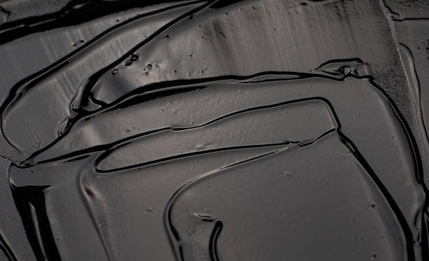 istock Cosmetic gel texture. Clear liquid cream with bubbles smudged on black background 1283538707