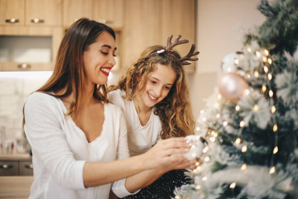 istock Sisters are occupied by fixing Christmas tree decoration. 1283539698