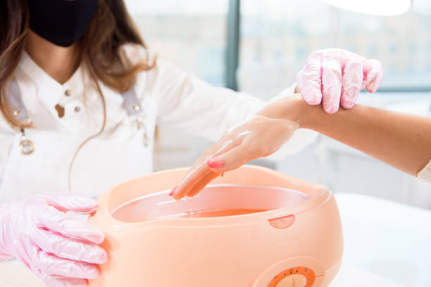 proceso tratamiento de parafina de manos femeninas en salón de belleza - paraffin fotografías e imágenes de stock