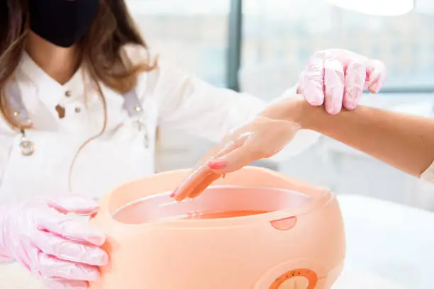 process paraffin treatment of female hands in a beauty salon