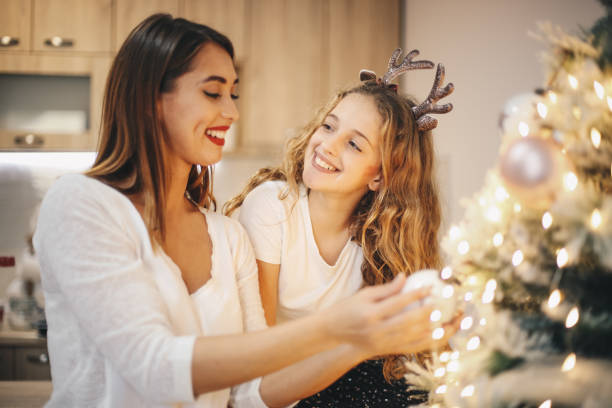 istock Two girls having fun while they decorate Christmas tree. 1283540079