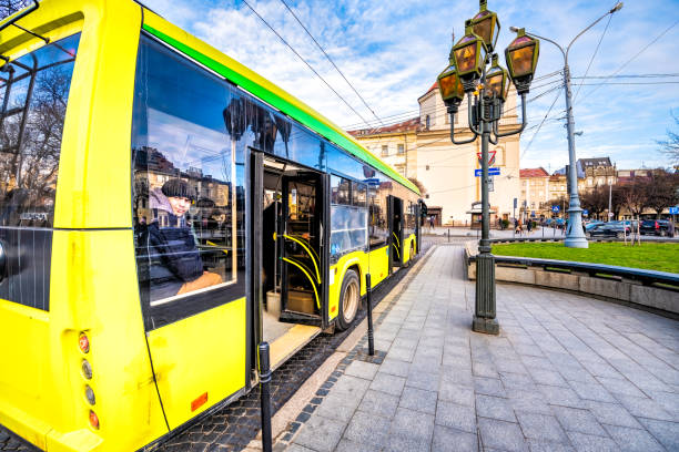 Lviv, Ukraine - January 21, 2020: Ukrainian Lvov city old town with yellow public transportation bus stop with people man sitting inside looking through window in downtown