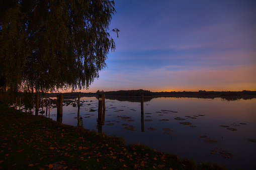 Sunset by the shore of a river in autumn