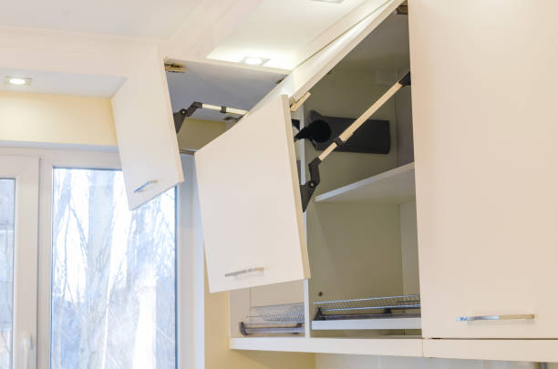 Kitchen wall cabinets with MDF facades and a folding opening mechanism in light beige, close-up