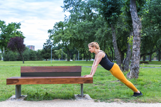 istock young woman doing standing push-ups outdoors 1283544930