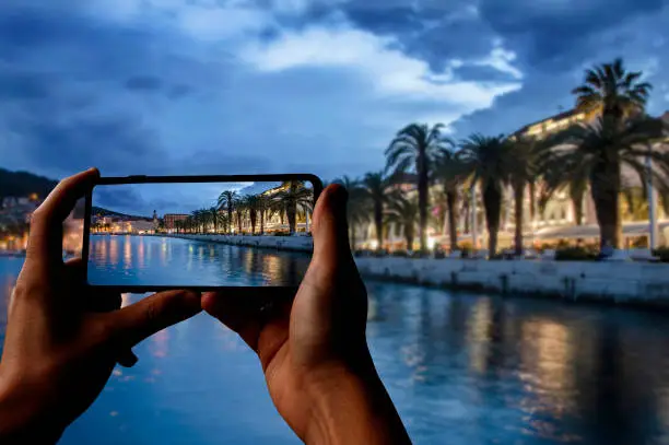 Tourist taking photo of promenade and sea in old town in Split, Croatia, Dalmatia, Europe.