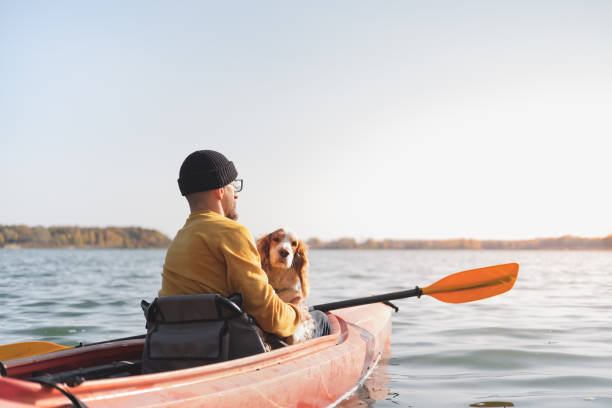 istock Man with a dog in a canoe on the lake. 1283546581
