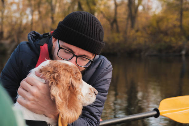 istock Man in a row boat kisses his dog. 1283546583